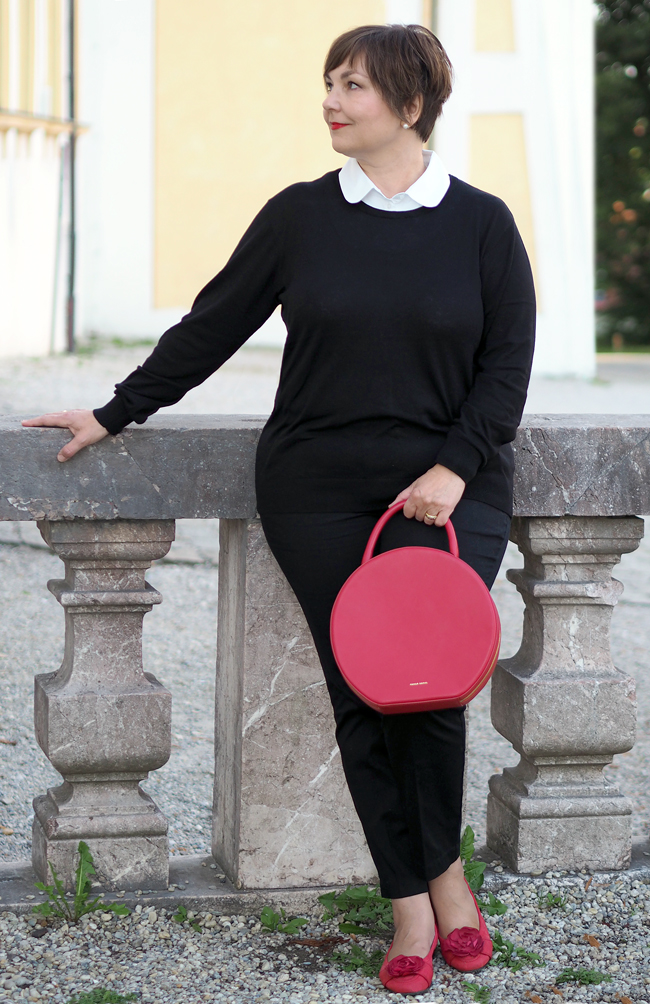 Typisch Pariser Stil: Schmale schwarze 7/8-Hose, Pullover mit Blusenkragen, Ballerinas, rote Lippen