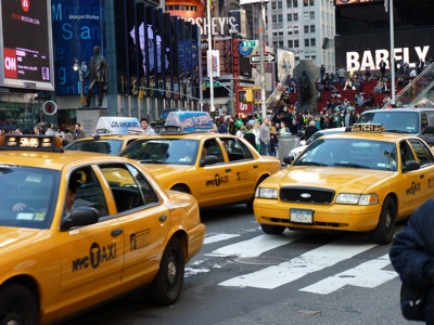Downtown New York. Eine Straßenszene mit drei der berühmten gelben Cabs im Vordergrund.