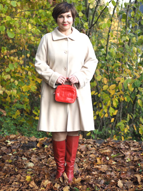 Weißer Mantel, rote Stiefel, rote Tasche.